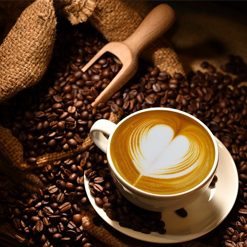 Kaffee mit Milchschaum und Kaffeebohnen