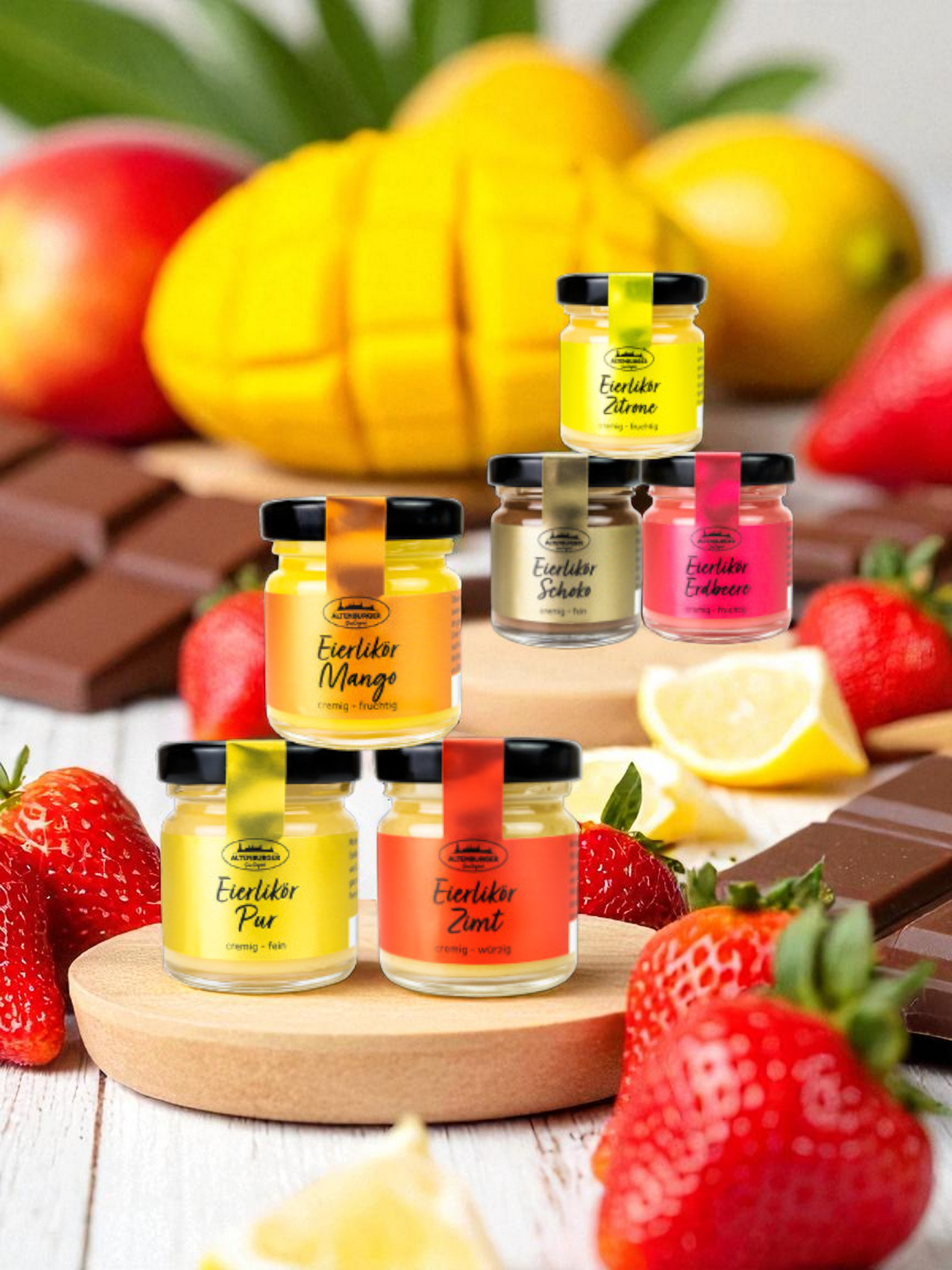 mini gläser eierlikör zum probieren arrangiert mit erdbeeren, mangos und schokolade